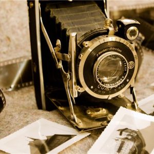 an image depicting on old camera with photographs displayed around it